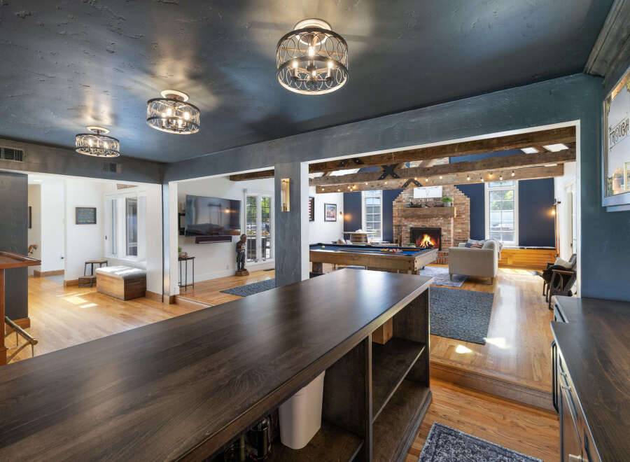 Experience ultimate entertainment in this stunning home featuring a spacious game room with a pool table and a cozy living area with a fireplace.