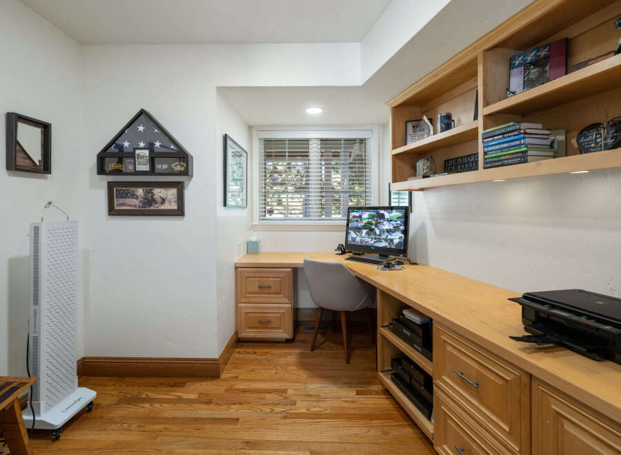 This home office features a built-in wooden desk and shelving unit, perfect for organizing your work essentials.