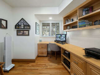 This home office features a built-in wooden desk and shelving unit, perfect for organizing your work essentials.
