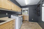 This laundry room boasts ample storage with light wood cabinets lining the walls and a spacious countertop.