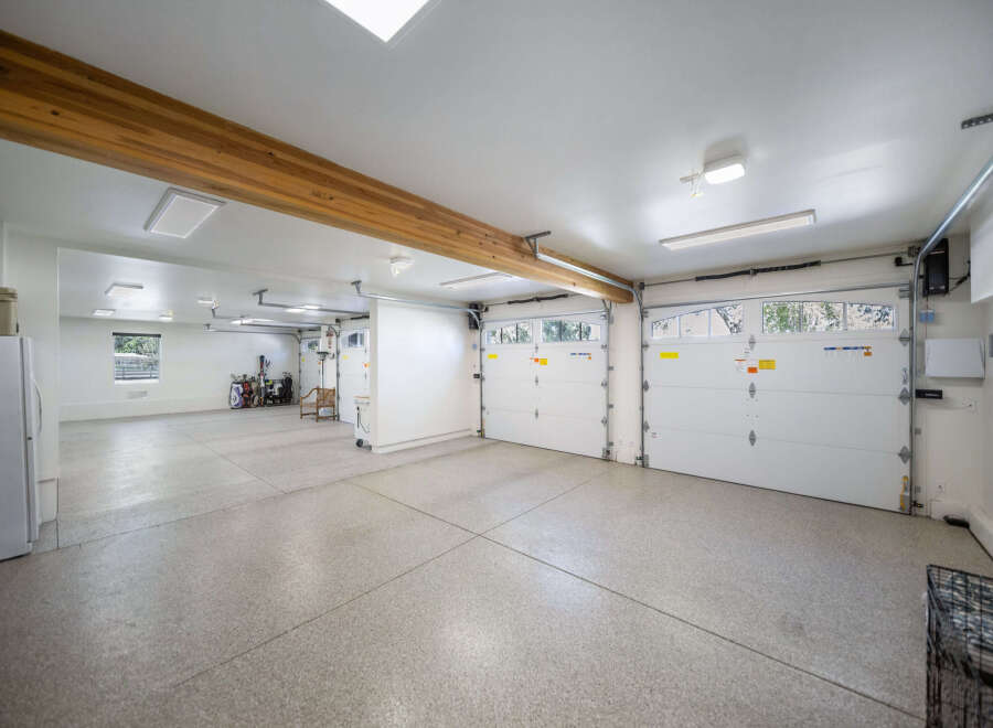 This spacious garage offers ample parking and storage with its multi-car capacity and high ceilings.