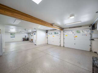 This spacious garage offers ample parking and storage with its multi-car capacity and high ceilings.