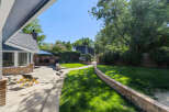 Enjoy outdoor living in this spacious backyard featuring a charming brick patio and a lush green lawn perfect for recreation.