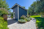 Discover this charming blue shed, perfect for storage or a backyard studio, nestled in a beautifully landscaped garden.