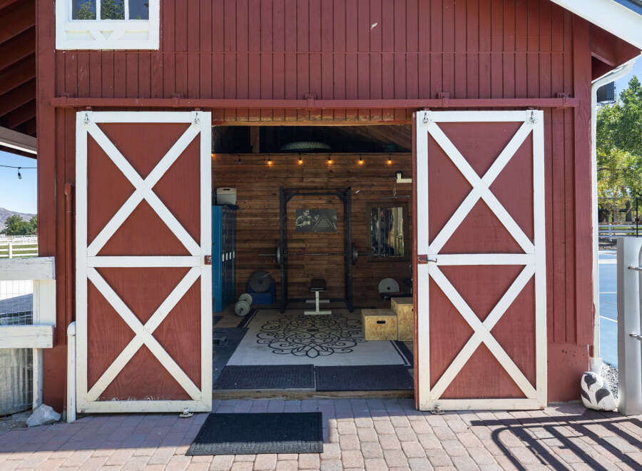 This charming red barn features a spacious interior, perfect for a home gym or workshop.