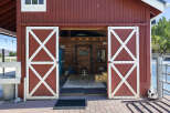 This charming red barn features a spacious interior, perfect for a home gym or workshop.