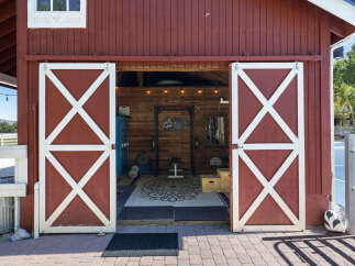This charming red barn features a spacious interior, perfect for a home gym or workshop.