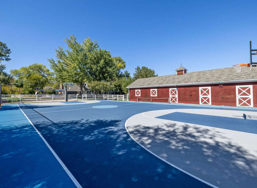 Enjoy outdoor recreation on this expansive blue and grey basketball court, complete with a full-size hoop.