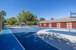 Enjoy outdoor recreation on this expansive blue and grey basketball court, complete with a full-size hoop.