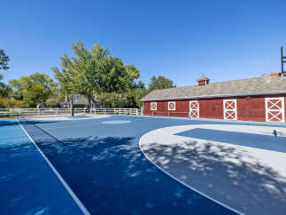 Enjoy outdoor recreation on this expansive blue and grey basketball court, complete with a full-size hoop.