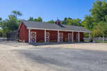 This charming red barn offers ample space with multiple stalls, perfect for equestrian enthusiasts or as a versatile workshop.