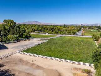 Discover this expansive property featuring a charming red barn and a spacious riding arena, perfect for equestrian enthusiasts.