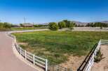 Discover this expansive property featuring a charming white vinyl fence that encloses a lush green pasture, perfect for equestrian activities or simply enjoying the open space.
