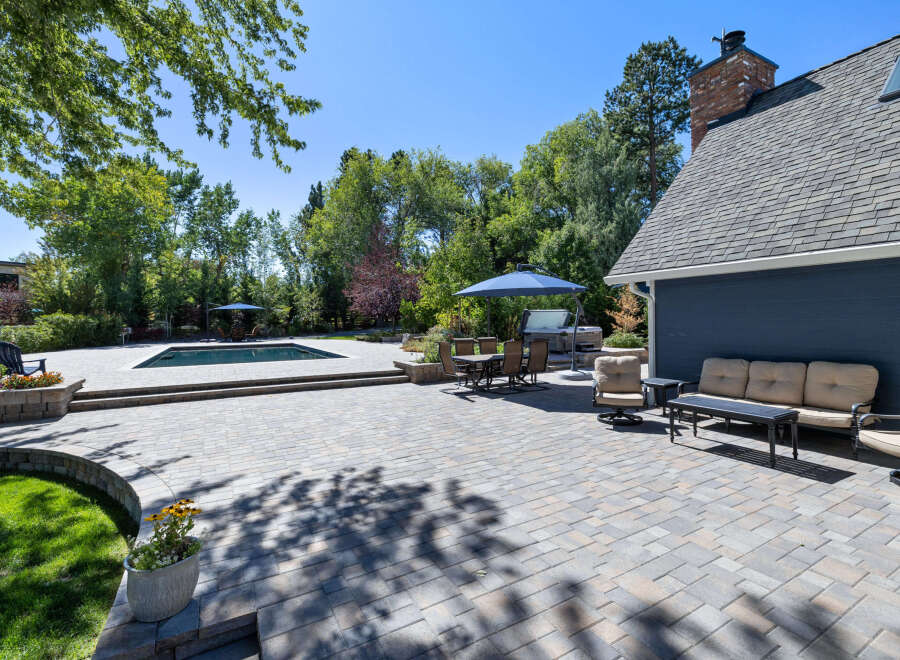 Enjoy outdoor living at its finest with this expansive patio featuring a sparkling swimming pool and a luxurious hot tub.