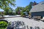 Enjoy outdoor living at its finest with this expansive patio featuring a sparkling swimming pool and a luxurious hot tub.