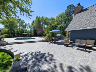 Enjoy outdoor living at its finest with this expansive patio featuring a sparkling swimming pool and a luxurious hot tub.