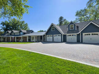 This stunning property boasts a spacious multi-car garage with elegant white doors, perfect for car enthusiasts or large families.