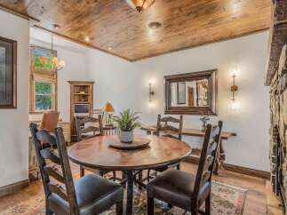 Experience rustic charm in this inviting dining area, featuring a substantial wooden table perfect for gatherings.