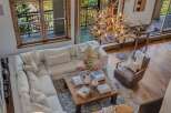 Experience rustic luxury in this stunning living room, featuring a plush sectional sofa and a unique antler chandelier that adds a touch of natural elegance.
