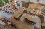 Experience rustic elegance in this spacious open-concept living area, featuring a large wooden dining table perfect for gatherings and a stunning granite-topped kitchen island with ample seating.
