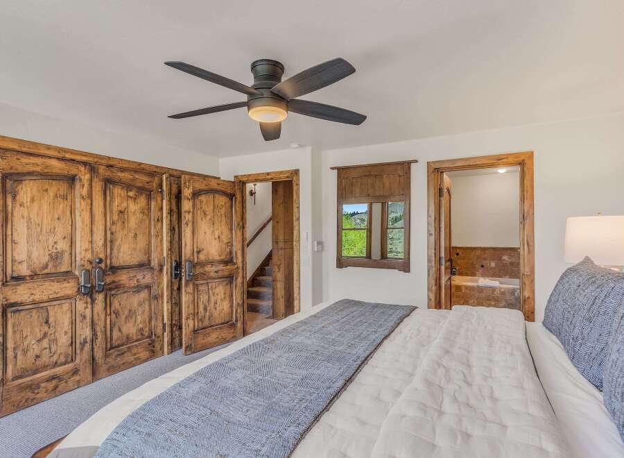 Experience rustic luxury in this charming bedroom featuring a plush king-sized bed adorned with a textured throw.