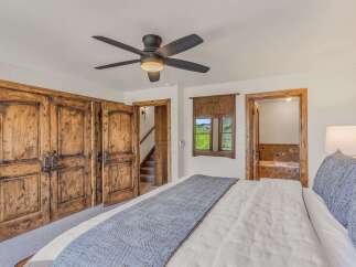 Experience rustic luxury in this charming bedroom featuring a plush king-sized bed adorned with a textured throw.