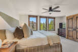Experience luxurious mountain living in this stunning bedroom, featuring a plush king-size bed adorned with decorative pillows and a cozy quilted throw.