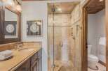 Experience luxury in this stunning bathroom featuring a spacious walk-in shower with elegant stone tile and a glass enclosure.