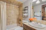 Charming bathroom featuring a bathtub with a decorative tile surround showcasing woodland creatures.