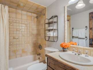 Charming bathroom featuring a bathtub with a decorative tile surround showcasing woodland creatures.