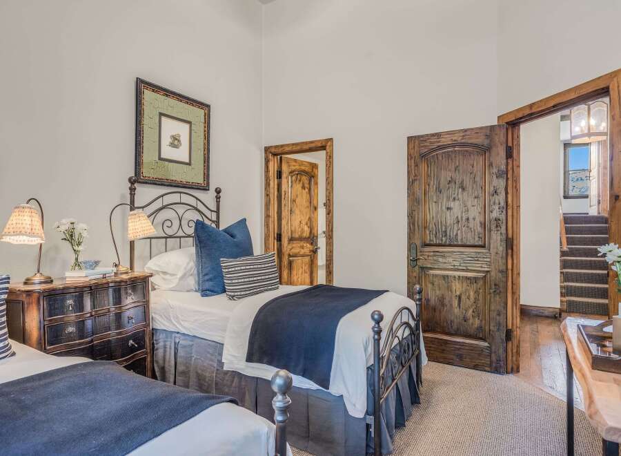 This charming bedroom features two twin beds with dark metal frames, perfect for accommodating guests.