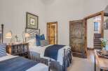 This charming bedroom features two twin beds with dark metal frames, perfect for accommodating guests.