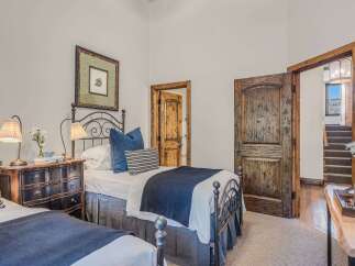 This charming bedroom features two twin beds with dark metal frames, perfect for accommodating guests.