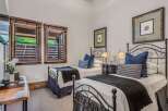 This charming bedroom features two twin beds with elegant black metal frames, perfect for accommodating guests.