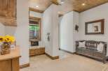 Step into this charming entryway featuring a rustic wooden ceiling and a cozy built-in bench with storage.
