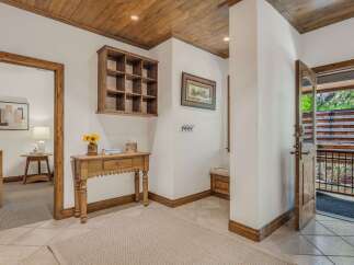 Step into this charming entryway featuring a rustic wooden ceiling and a decorative shelf.
