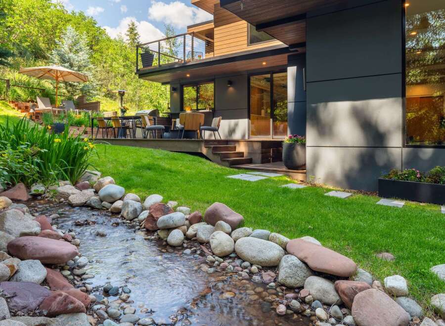 Experience luxury outdoor living with this stunning property featuring a modern home design seamlessly integrated with nature.