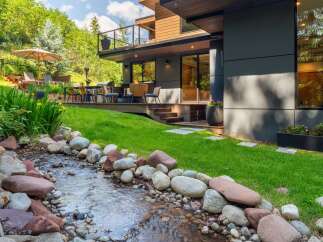 Experience luxury outdoor living with this stunning property featuring a modern home design seamlessly integrated with nature.