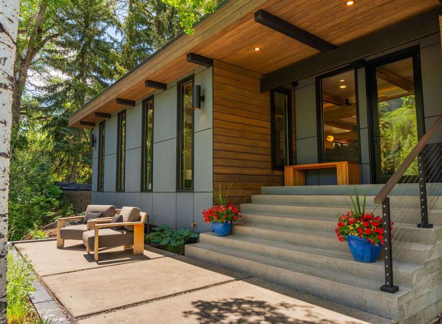 Experience modern living with this stunning home featuring a sleek exterior of wood and gray paneling.