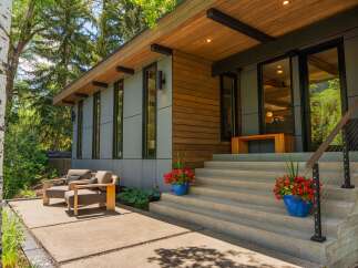 Experience modern living with this stunning home featuring a sleek exterior of wood and gray paneling.