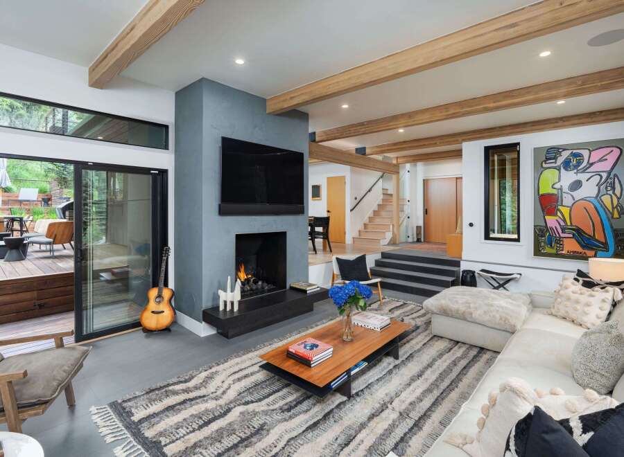 Experience modern living in this stunning open-concept living space, featuring a cozy fireplace and a large flat-screen TV.