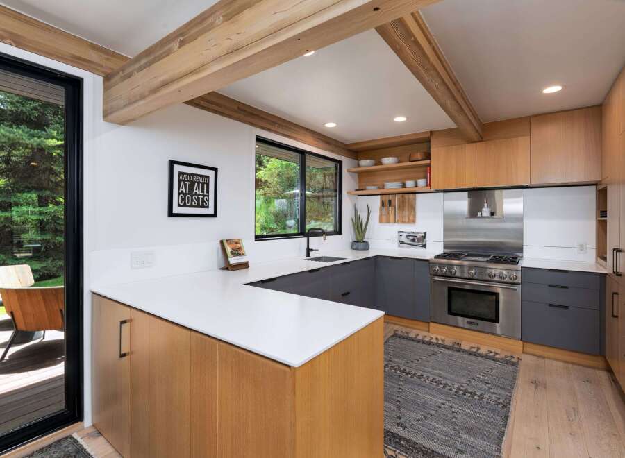 Experience modern living in this stunning kitchen featuring sleek, dark gray cabinetry contrasted with warm, natural wood accents.