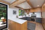 Experience modern living in this stunning kitchen featuring sleek, dark gray cabinetry contrasted with warm, natural wood accents.