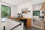 Discover a modern workspace with a large window offering serene forest views.