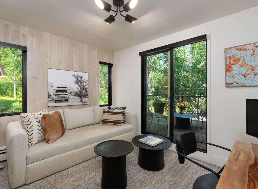 Experience modern living in this stylish room featuring a comfortable sofa, two chic black side tables, and a striking black and white photograph.