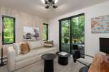 Experience modern living in this stylish room featuring a comfortable sofa, two chic black side tables, and a striking black and white photograph.