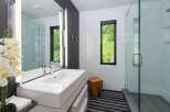 Experience modern luxury in this stunning bathroom featuring a sleek vessel sink atop a minimalist vanity.