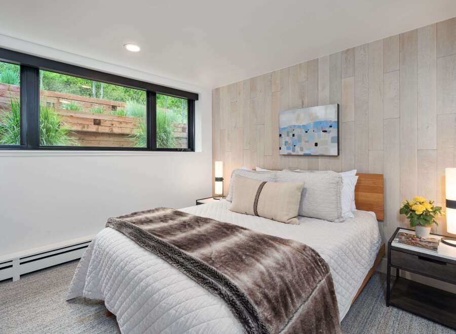 Experience serene living in this beautifully appointed bedroom, featuring a plush queen-size bed adorned with a luxurious faux fur throw.
