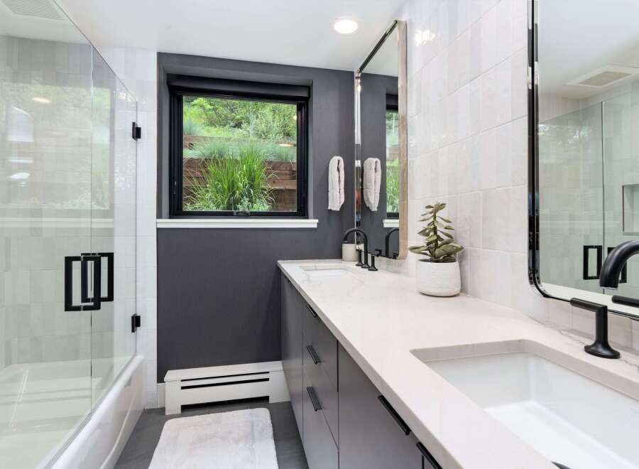 Experience modern luxury in this stunning bathroom featuring a sleek dual vanity with quartz countertops and elegant black fixtures.