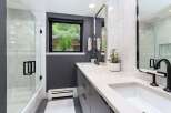 Experience modern luxury in this stunning bathroom featuring a sleek dual vanity with quartz countertops and elegant black fixtures.